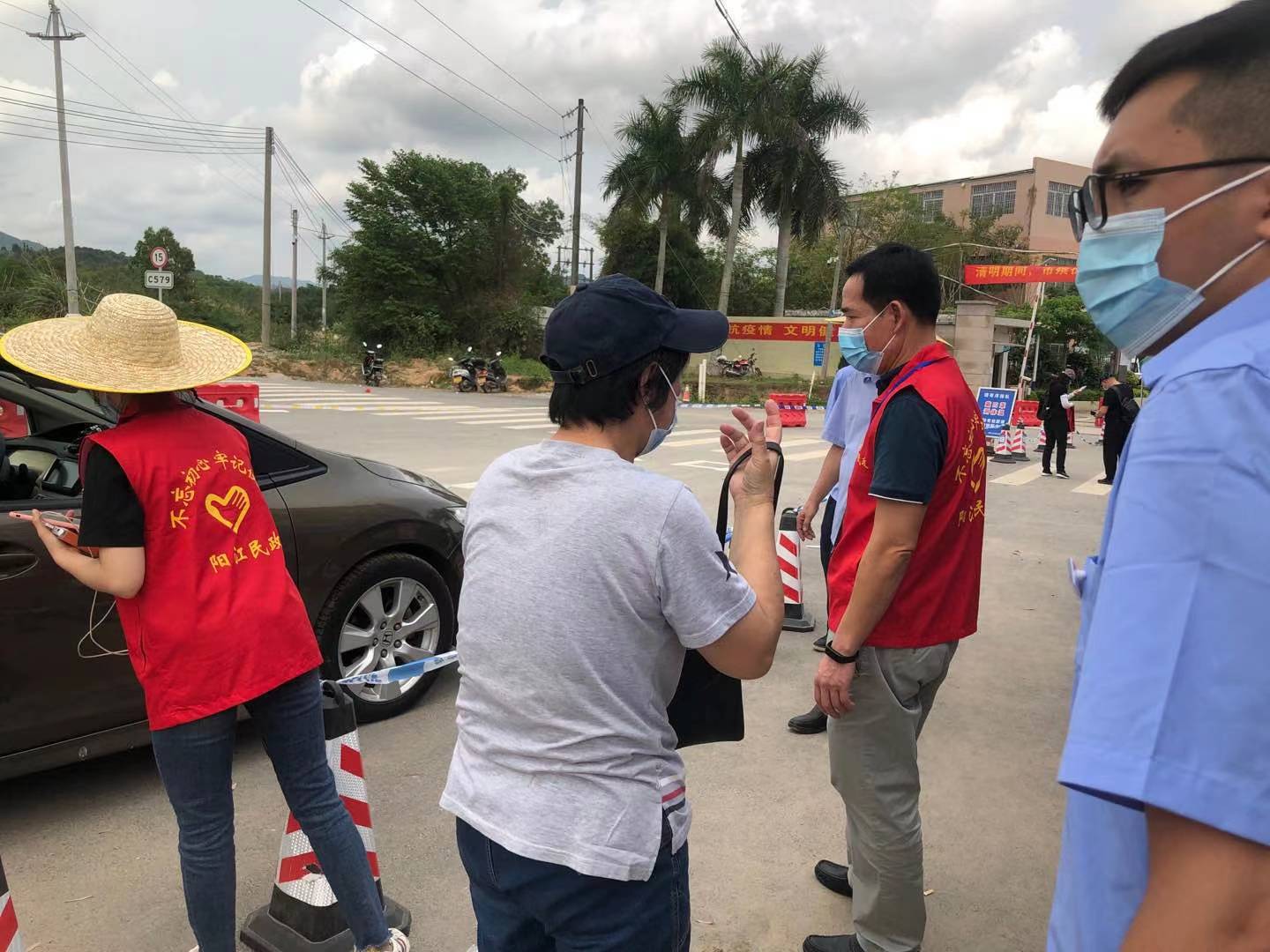 志愿者协助查看出入人员的健康码并检测体温.jpg